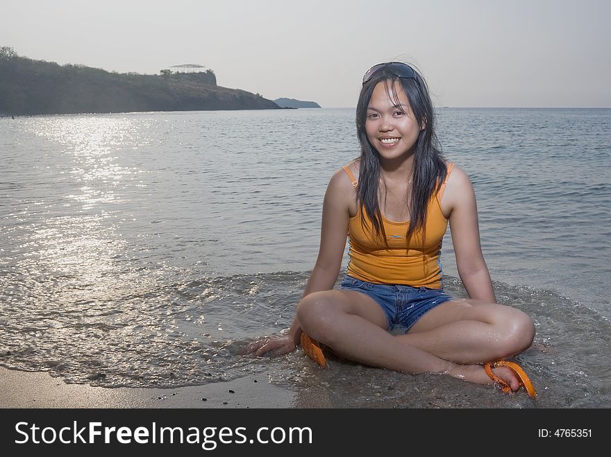 Asian woman sitting on beach