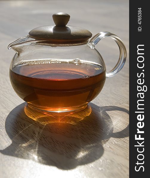 Transparent cup of tea on a wooden floor. Transparent cup of tea on a wooden floor.