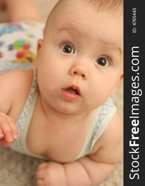 The surprised child lays on a floor