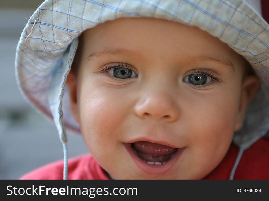 Smiling boy with blue hat on the head