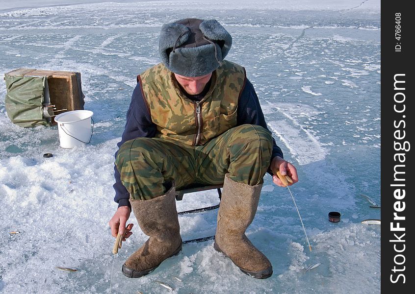 A winter fishing on river. People is fishing the smelt. Russian Far East, Primorye, Kievka river. A winter fishing on river. People is fishing the smelt. Russian Far East, Primorye, Kievka river.