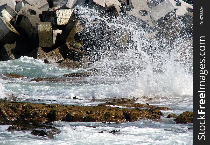 Splash of water on rocks in front of dolosa. Splash of water on rocks in front of dolosa