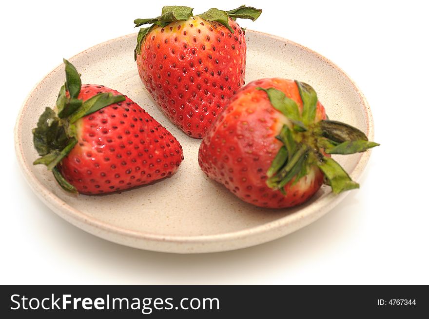 Strawberries berries on the ceramic plate, isolated on a white background