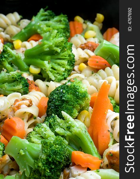 Close-up of cooking vegetables, chicken and pasta