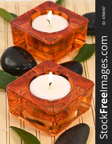 Spa stones, candles and green leaves on bamboo. Spa stones, candles and green leaves on bamboo