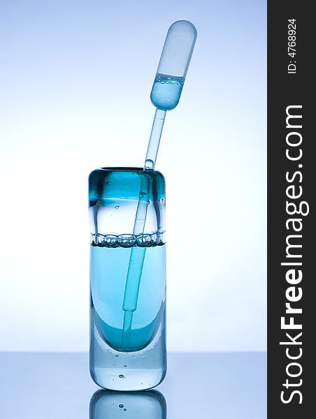 Glass container with blue liquid and measuring stick. Glass container with blue liquid and measuring stick