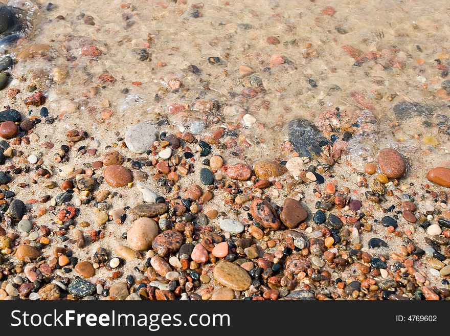 Wet pebbles on a beach background. Wet pebbles on a beach background