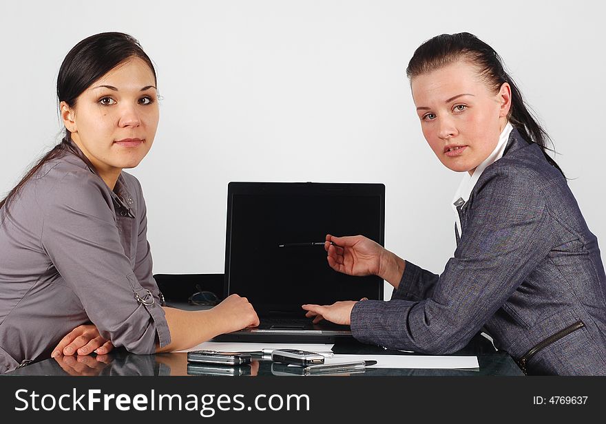 Two attractive brunette businesswomen working in office. Two attractive brunette businesswomen working in office