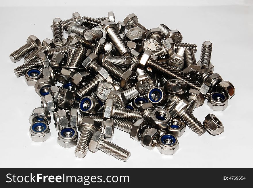 A lot of nuts and bolts in a single pile on a white background