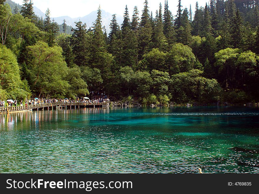 Lake in Jiuzaigou nature protection area, Sichuan province, South-West China. 

Jiuzaigou translates to: nine village valley. It is a well know area in China. About 20000 tourists per day are visiting Jiuzaigou.