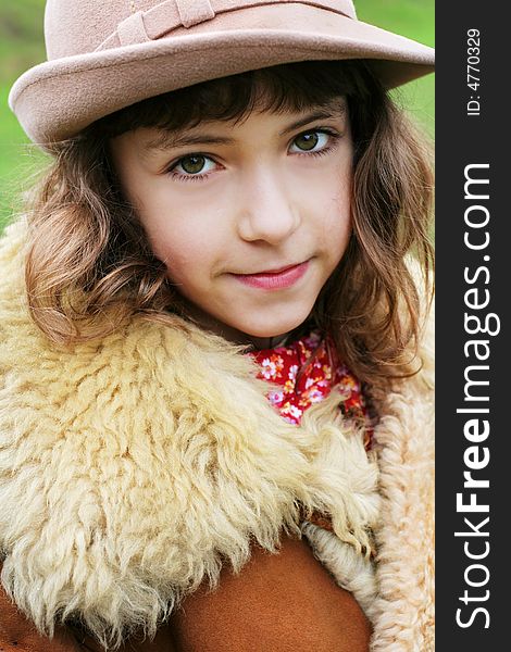Cute smiling girl wearing a hat and vintage winter fur coat. Cute smiling girl wearing a hat and vintage winter fur coat