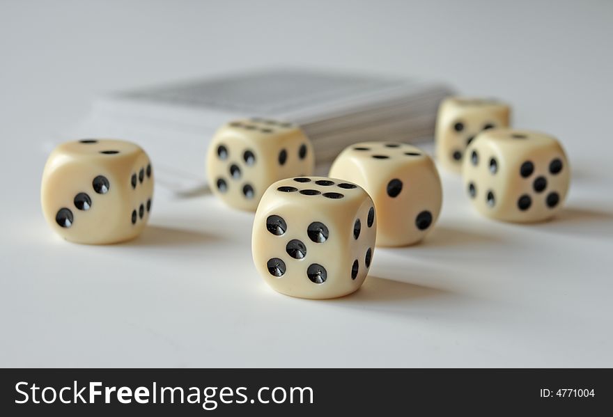 Dice and cards on a white table,focus on a foreground