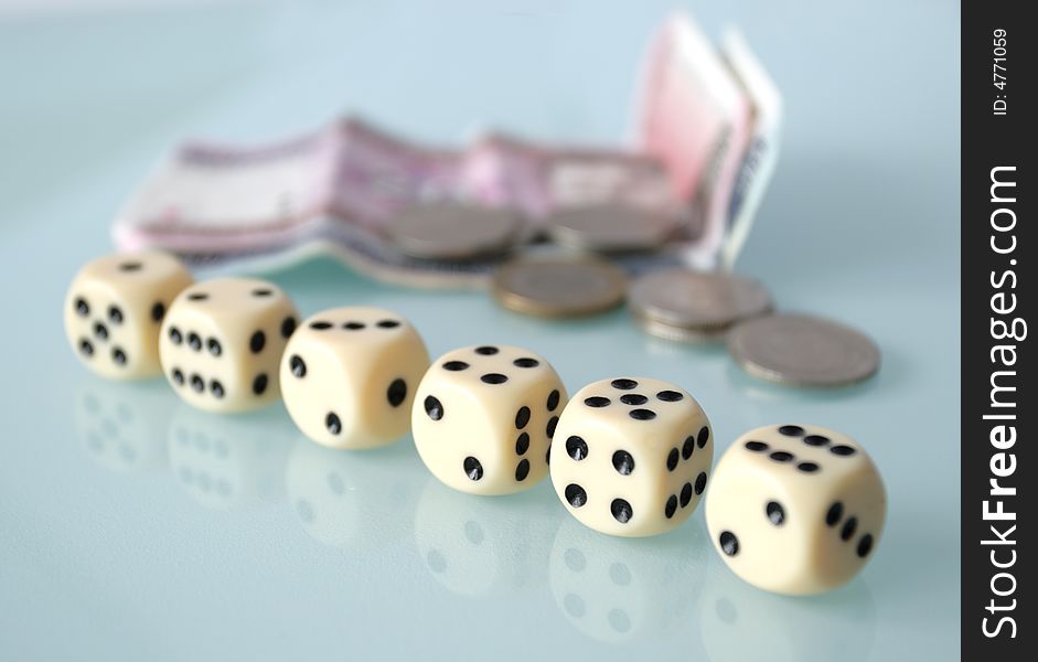 Dice and money on a glass table,focus on a foreground