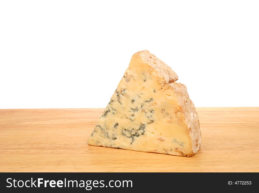 A wedge of Stilton cheese on a board