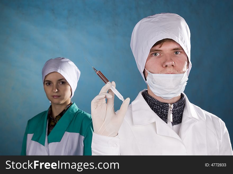 The medical worker with a syringe in a hand. The medical worker with a syringe in a hand.