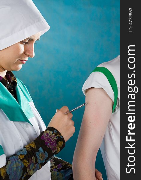 Young female doctor giving injection of insulin to a patient.