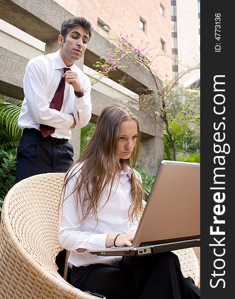 Businessman and woman looking at a laptop together. Businessman and woman looking at a laptop together.