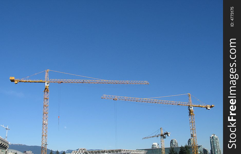 Yellow construction cranes in the sky