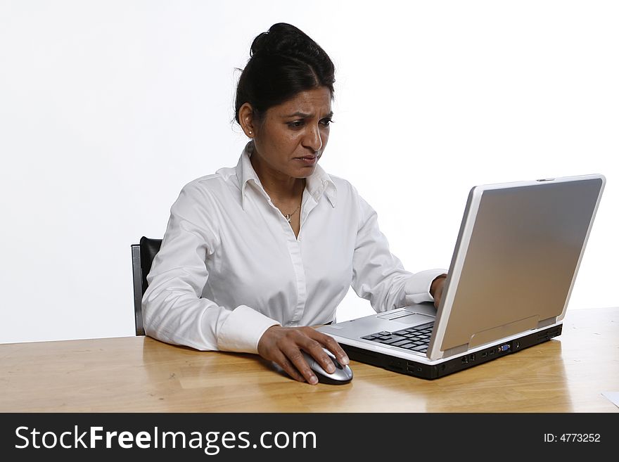 Indian woman looking concerned while working on her laptop. Indian woman looking concerned while working on her laptop