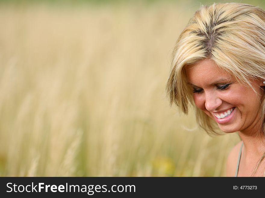 Beautiful blond woman smiling in a high grass. Beautiful blond woman smiling in a high grass