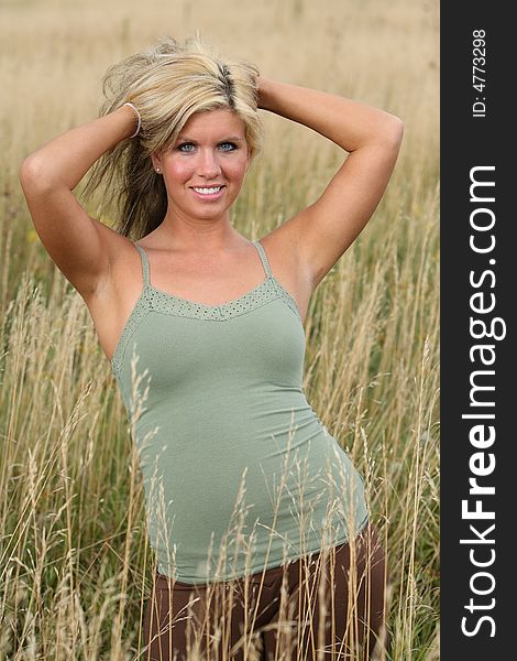 Beautiful blond woman smiling in a high grass. Beautiful blond woman smiling in a high grass
