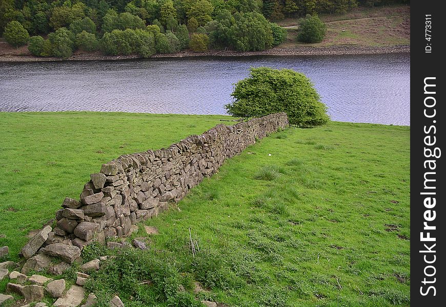 Dry stone wall in field with water. Dry stone wall in field with water