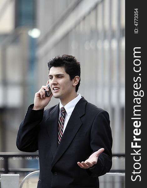 Business man gesturing while talking on his cell phone outdoors. Business man gesturing while talking on his cell phone outdoors