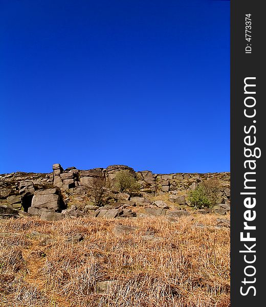 Rock edge with blue sky and moorland foreground. Rock edge with blue sky and moorland foreground