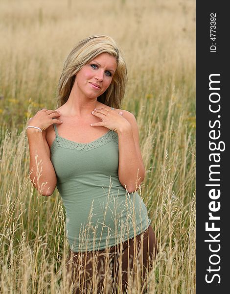 Beautiful blond woman standing in a high grass. Beautiful blond woman standing in a high grass