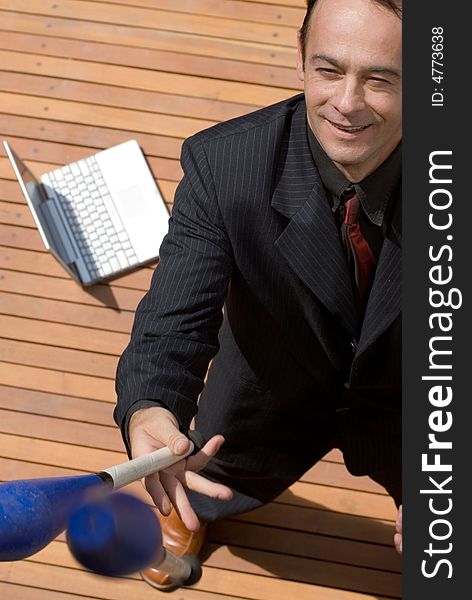 Man in a business suit smiling and juggling with his laptop in the background. Man in a business suit smiling and juggling with his laptop in the background