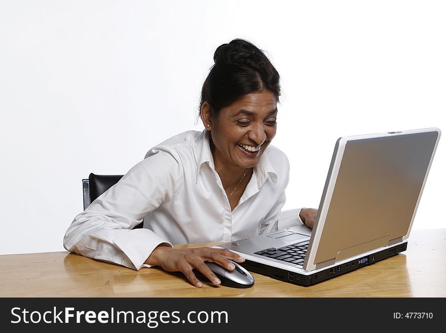 Indian woman laughing heartily at her laptop. Indian woman laughing heartily at her laptop