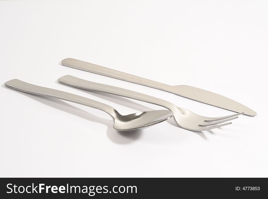 Metal spoon, fork and knife on a white background. Metal spoon, fork and knife on a white background