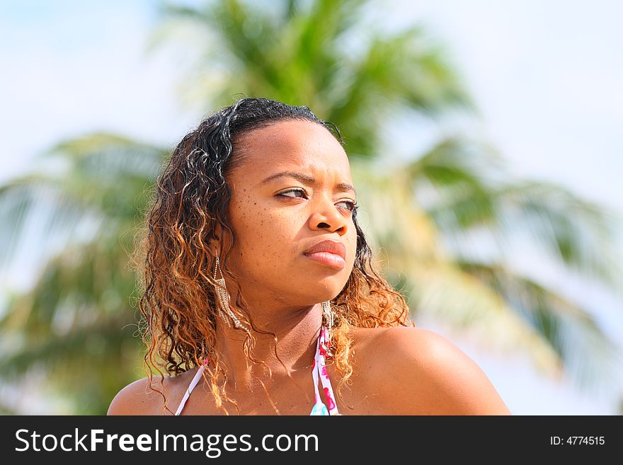 Woman outside with a blurry palm tree background