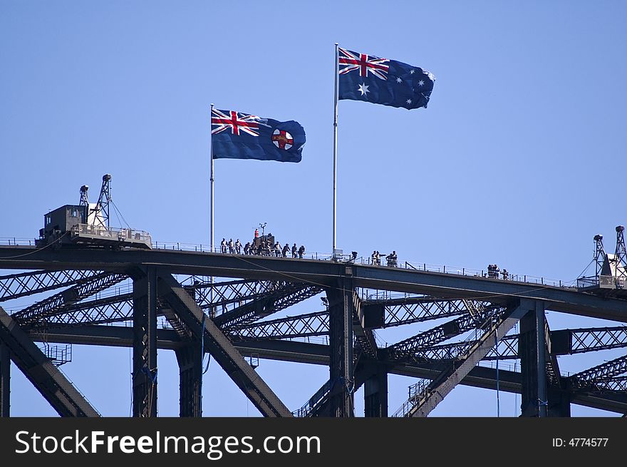 Groups of tourists on top of sydney harbor bridge with two australian flags. Groups of tourists on top of sydney harbor bridge with two australian flags