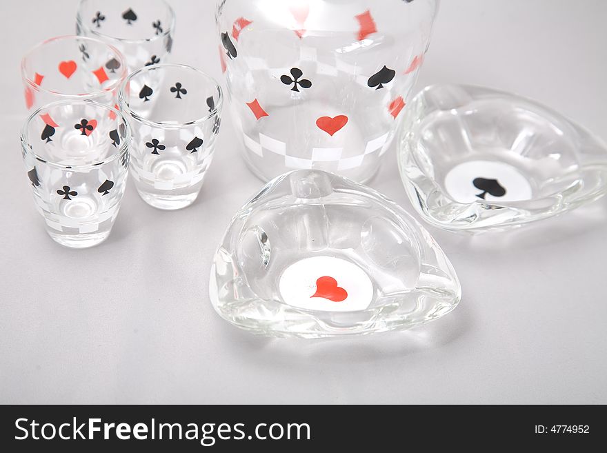 A set of liquor glasses and ashtrays with cards pattern