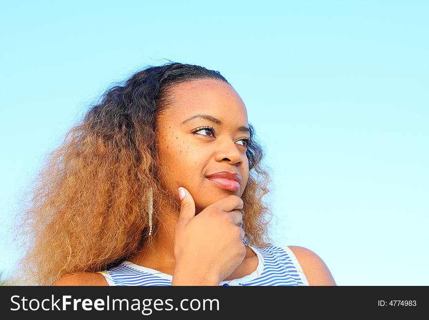 Woman smiling with her hand on her chin.