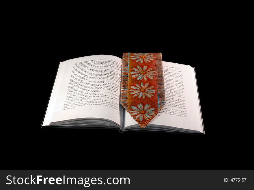 Open book with tassel against black background