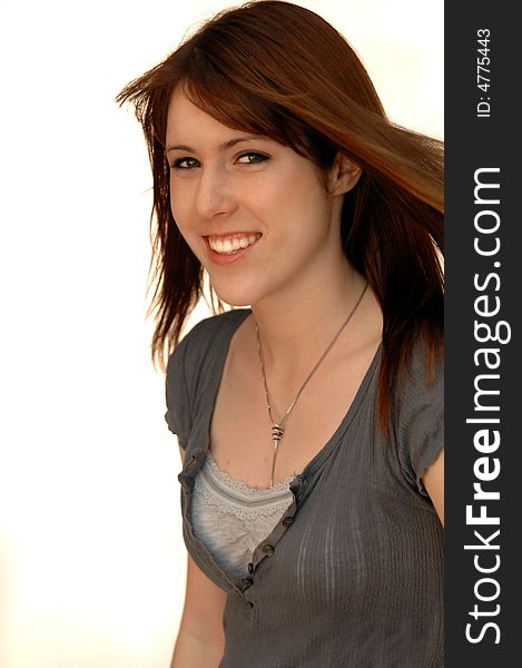 Portrait of a beautiful girl with brown straight hair blowing against white background. Portrait of a beautiful girl with brown straight hair blowing against white background.