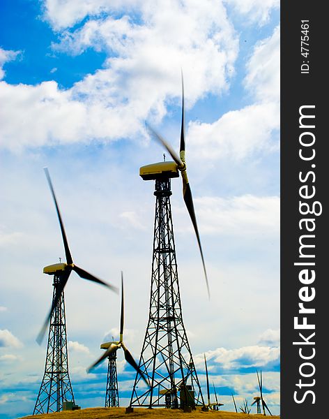 A group of wind turbines produce electricity. A group of wind turbines produce electricity