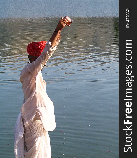 Hindu people worship all the natural elements like water, fire etc. They have a tradition of worshiping nature itself like sun, river etc. Here the man is doing \Surya Puja\ at Pushkar lake, Rajathan. Hindu people worship all the natural elements like water, fire etc. They have a tradition of worshiping nature itself like sun, river etc. Here the man is doing \Surya Puja\ at Pushkar lake, Rajathan.