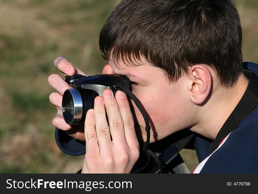 Young boy taking photos with black camera