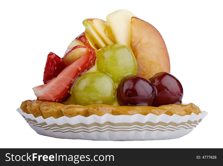 Close-up of a baked fruit tart in paper cup, isolated against white background (with clipping path)