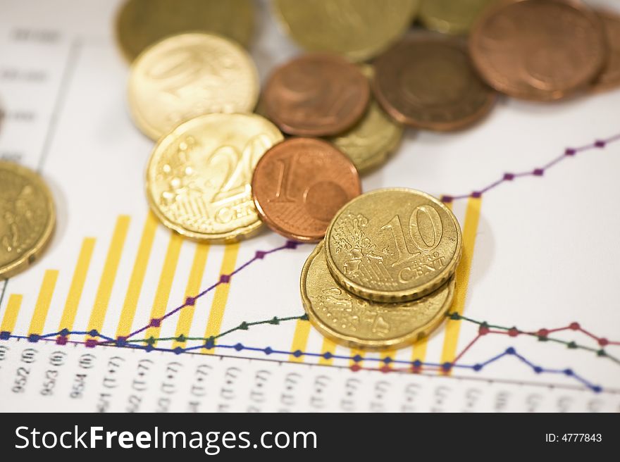 Euro coins on papers with financial data. Euro coins on papers with financial data.