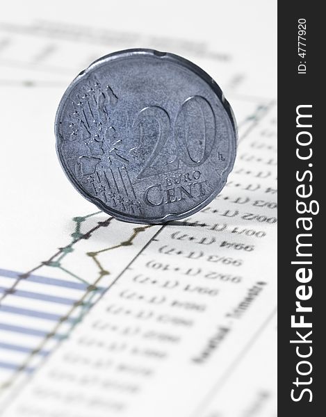 Euro twenty cent coin on financial data papers