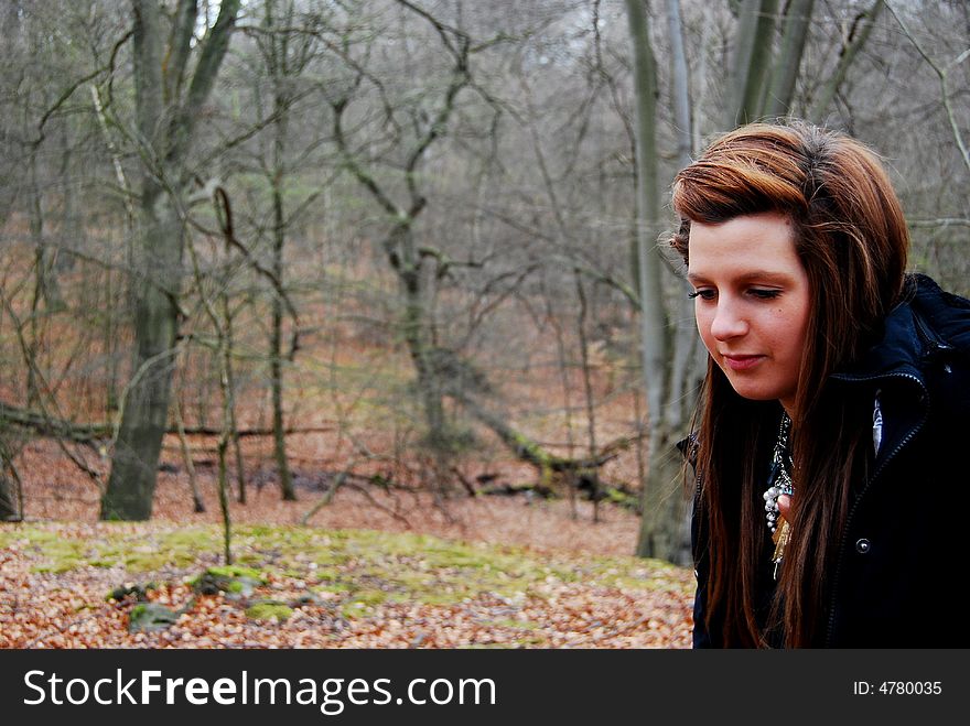 Woman walking through the forest on a cold day. Woman walking through the forest on a cold day.