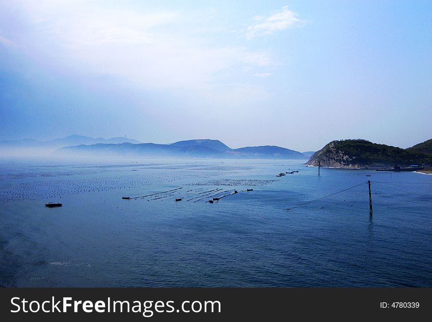 The Weihai Bay is famous for its picturesque scenery as well as blue skies, warm sunlight, fresh moist air, rolling green hills, primeval forests, calm bay, limpid seawater, and multi-colored seabed landscape .
