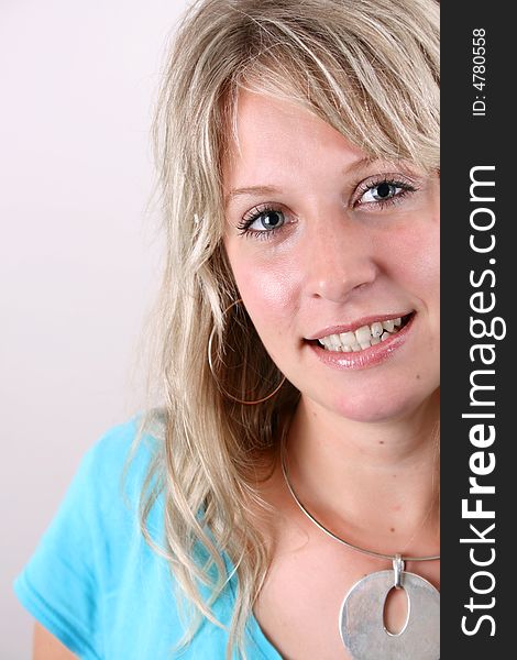 Blond Female model on a white background wearing a blue top. Blond Female model on a white background wearing a blue top