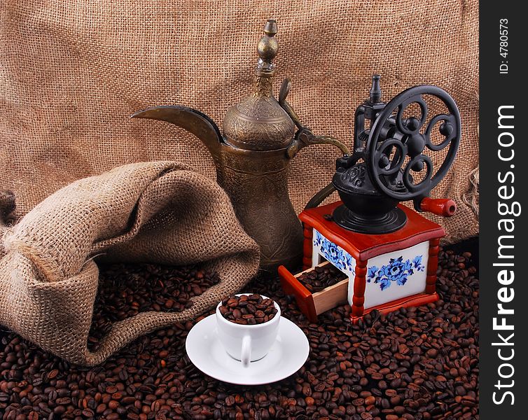 Fried coffee beans with a cup of coffee on top