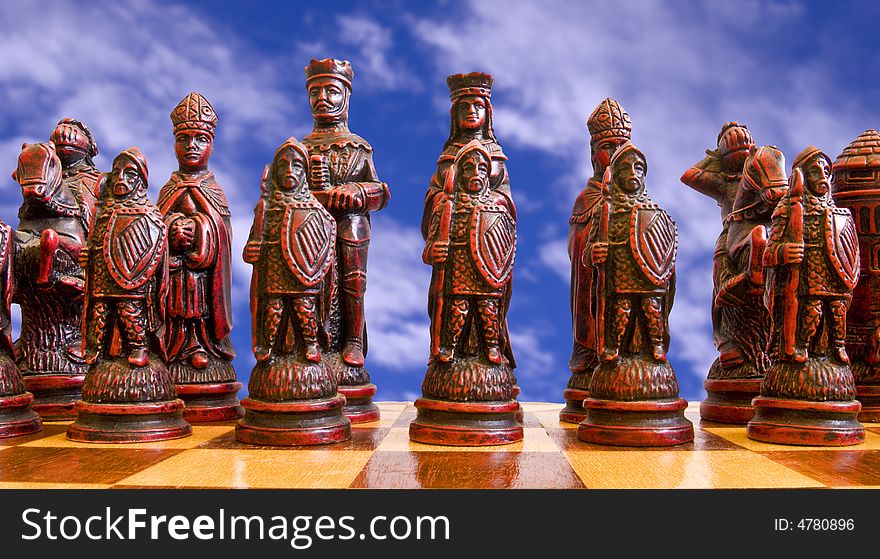 Red chess pieces pictured against a cloudy sky. Red chess pieces pictured against a cloudy sky