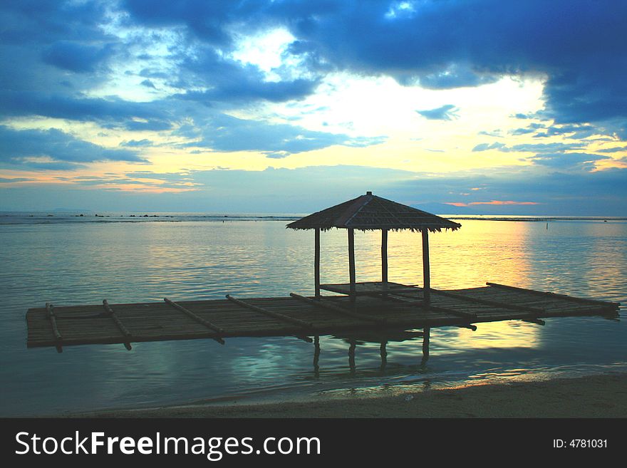 Silhouette of a floating hut on raft against the sunset. Silhouette of a floating hut on raft against the sunset